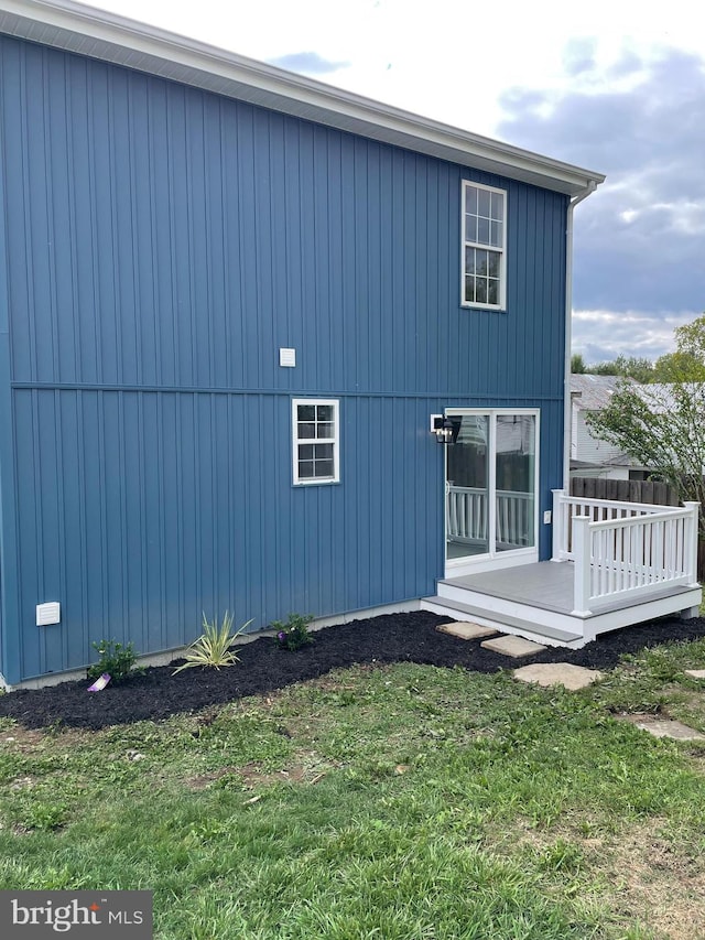 view of side of property featuring a yard and a wooden deck