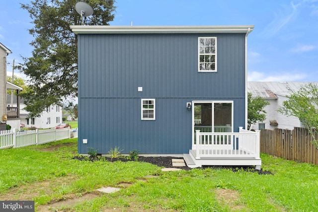 rear view of property with a deck and a yard