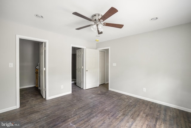 unfurnished bedroom featuring dark hardwood / wood-style floors, a spacious closet, ceiling fan, and a closet