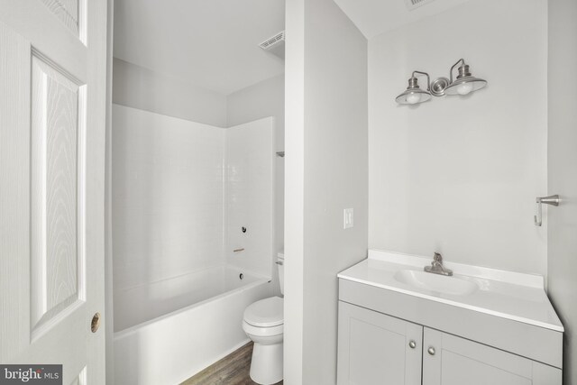 full bathroom with hardwood / wood-style floors, tub / shower combination, vanity, and toilet