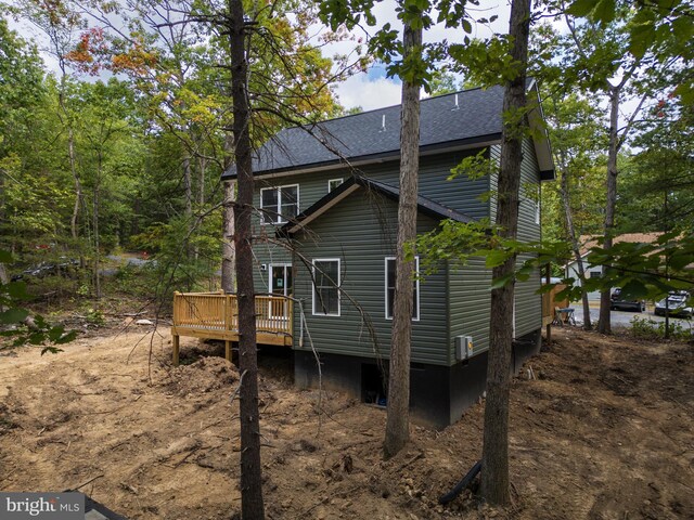 rear view of property featuring a wooden deck