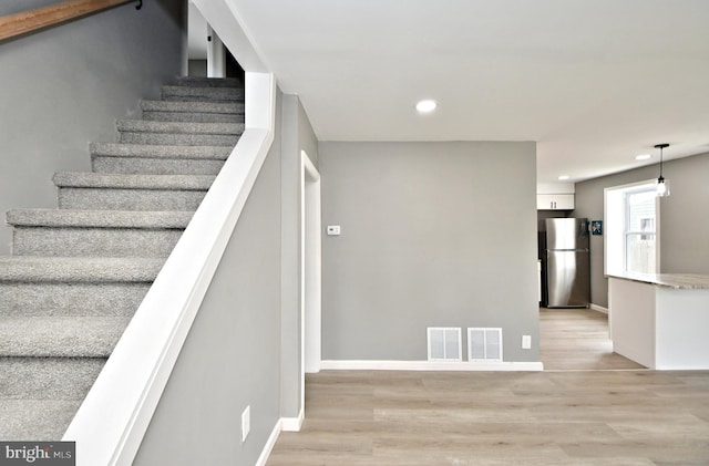 staircase with hardwood / wood-style flooring