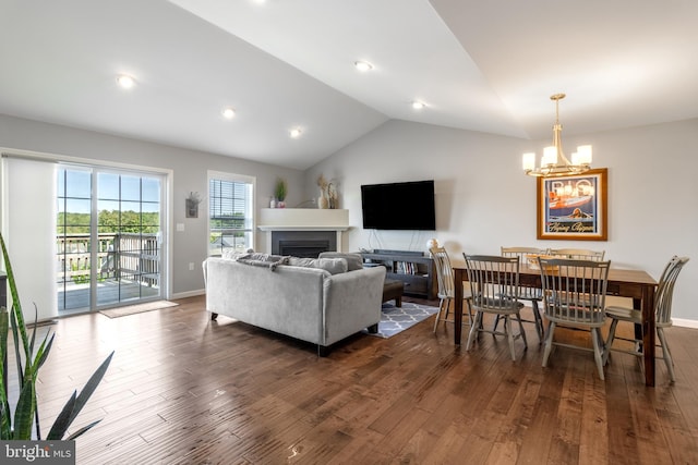 living room with a notable chandelier, lofted ceiling, and dark hardwood / wood-style flooring