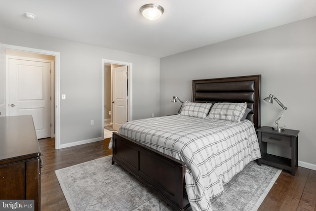 bedroom featuring ensuite bath and dark hardwood / wood-style flooring