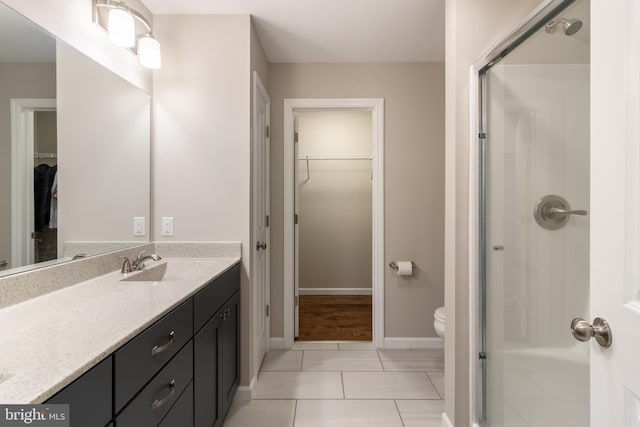 bathroom with vanity, tile patterned flooring, toilet, and a shower with door