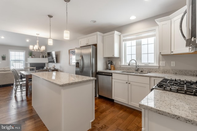 kitchen featuring a center island, dark wood-type flooring, stainless steel appliances, and white cabinets