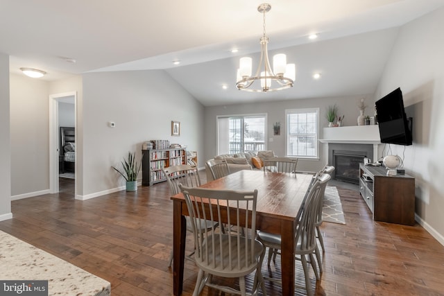 dining room featuring an inviting chandelier, vaulted ceiling, and dark hardwood / wood-style flooring