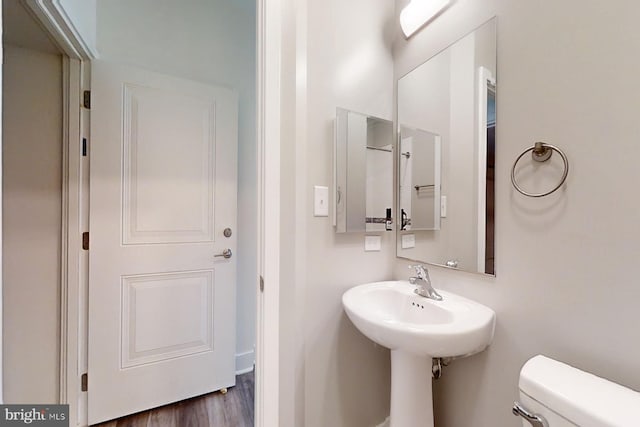 bathroom featuring hardwood / wood-style flooring and toilet