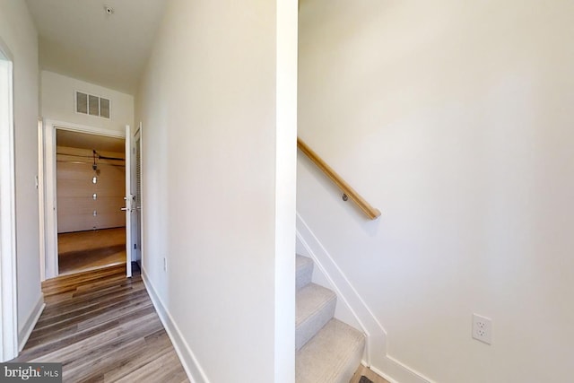 staircase with hardwood / wood-style flooring