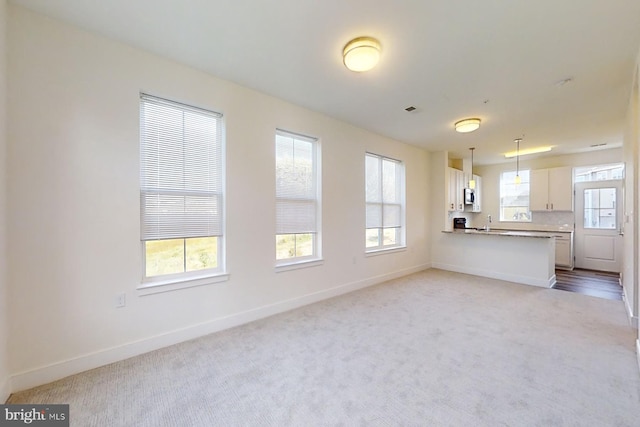 unfurnished living room featuring light colored carpet