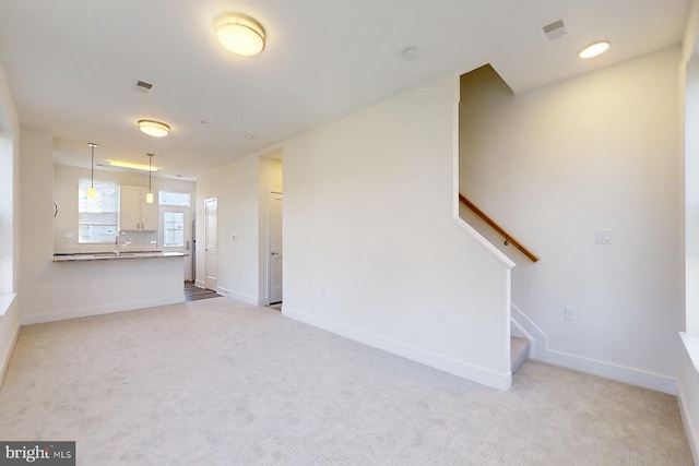 unfurnished living room with light colored carpet