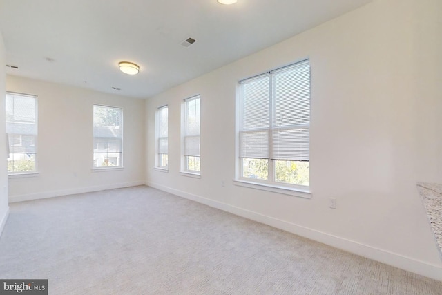 unfurnished room featuring light carpet