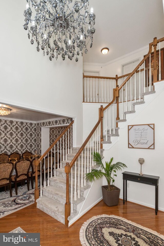 stairway featuring ornamental molding and hardwood / wood-style floors