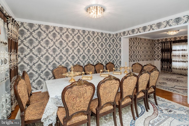 dining room featuring a notable chandelier, ornamental molding, and hardwood / wood-style floors