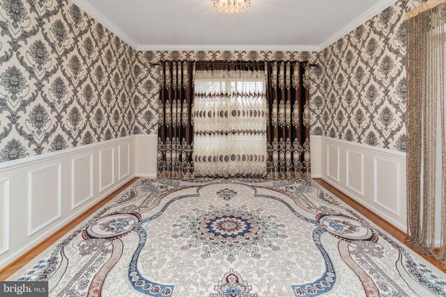 spare room with light hardwood / wood-style flooring and crown molding