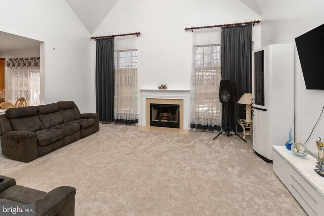 carpeted living room featuring high vaulted ceiling and a wealth of natural light