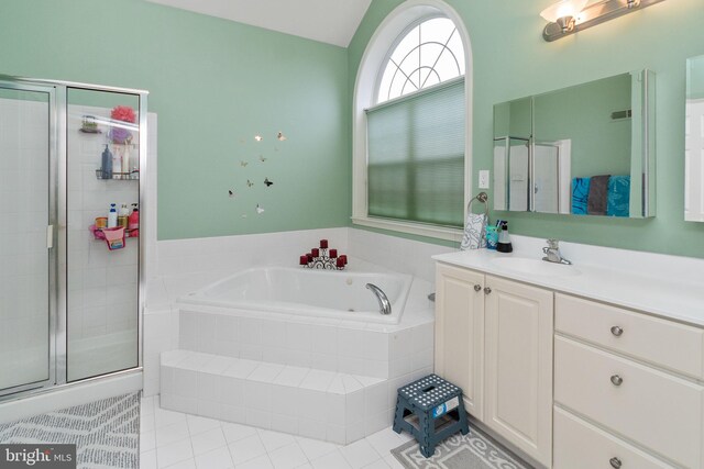 bathroom featuring shower with separate bathtub, vanity, and tile patterned floors