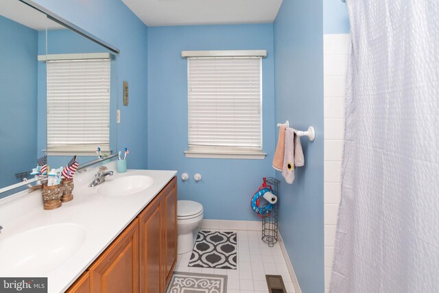 bathroom with a shower with curtain, vanity, toilet, and tile patterned floors