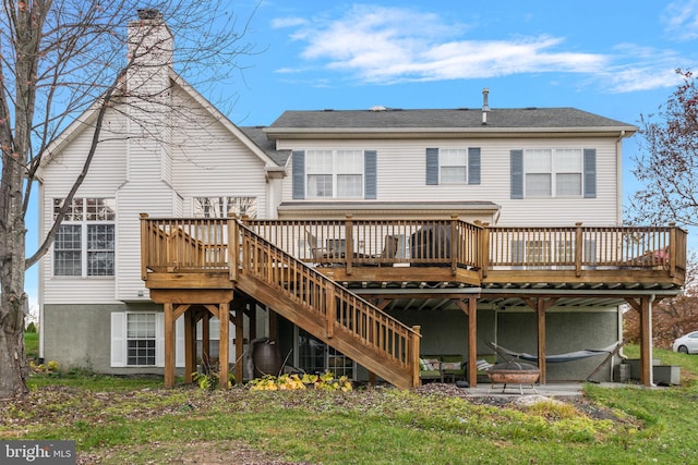 rear view of house featuring a lawn and a wooden deck