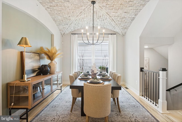 dining room featuring an inviting chandelier, brick ceiling, wood finished floors, baseboards, and vaulted ceiling