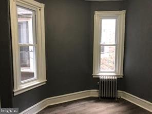 spare room featuring radiator and hardwood / wood-style flooring