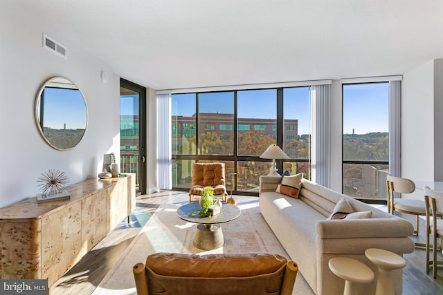 living room with floor to ceiling windows, light wood-type flooring, and plenty of natural light