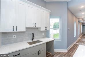 kitchen featuring plenty of natural light, sink, and white cabinetry