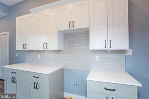 kitchen with white cabinetry and tasteful backsplash