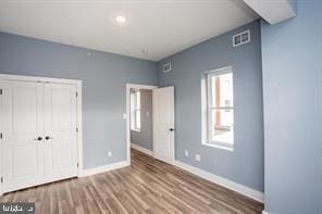 unfurnished bedroom with a closet and hardwood / wood-style floors