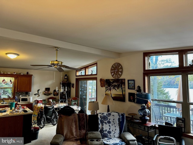 interior space featuring ceiling fan, lofted ceiling with beams, and a wealth of natural light