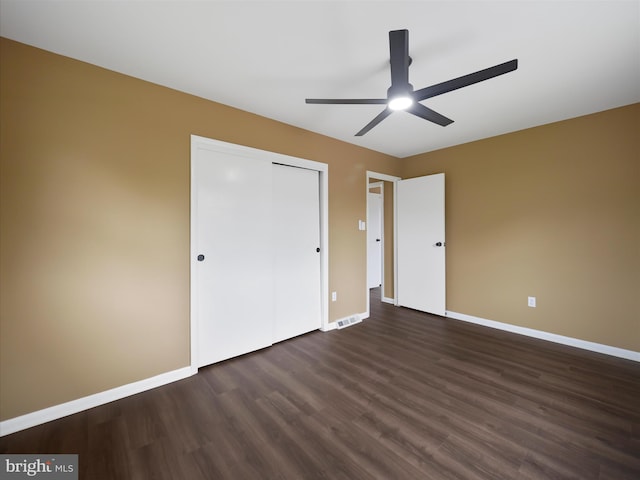 unfurnished bedroom featuring a closet, ceiling fan, and dark hardwood / wood-style flooring