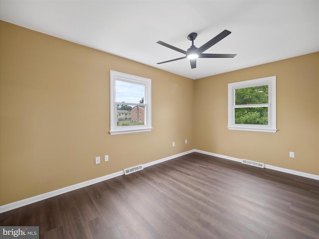 unfurnished room featuring ceiling fan, plenty of natural light, and dark wood-type flooring