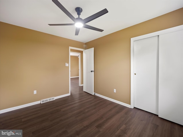 unfurnished bedroom with ceiling fan, a closet, and dark hardwood / wood-style flooring