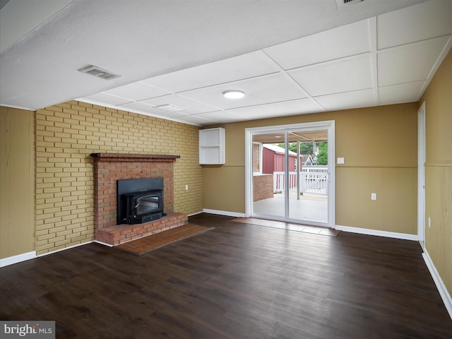 unfurnished living room featuring dark hardwood / wood-style flooring and a brick fireplace