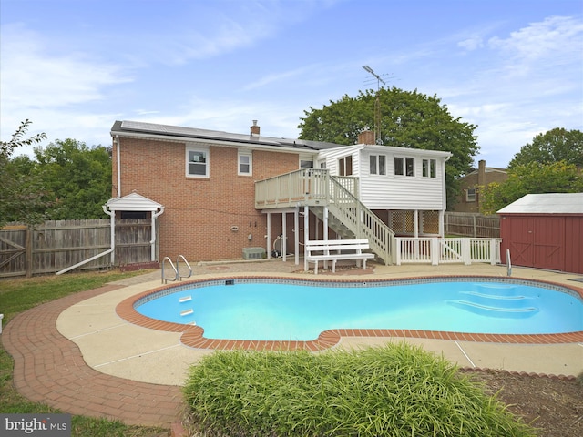 view of pool with a storage shed, a patio area, and a deck