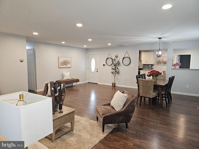 living room with dark wood-type flooring and a notable chandelier