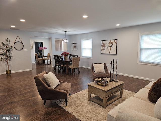 living room featuring a chandelier and dark hardwood / wood-style flooring