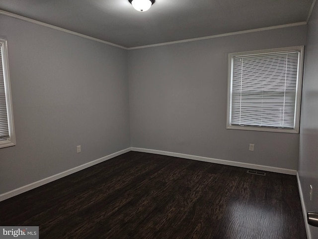 spare room featuring crown molding and dark hardwood / wood-style flooring