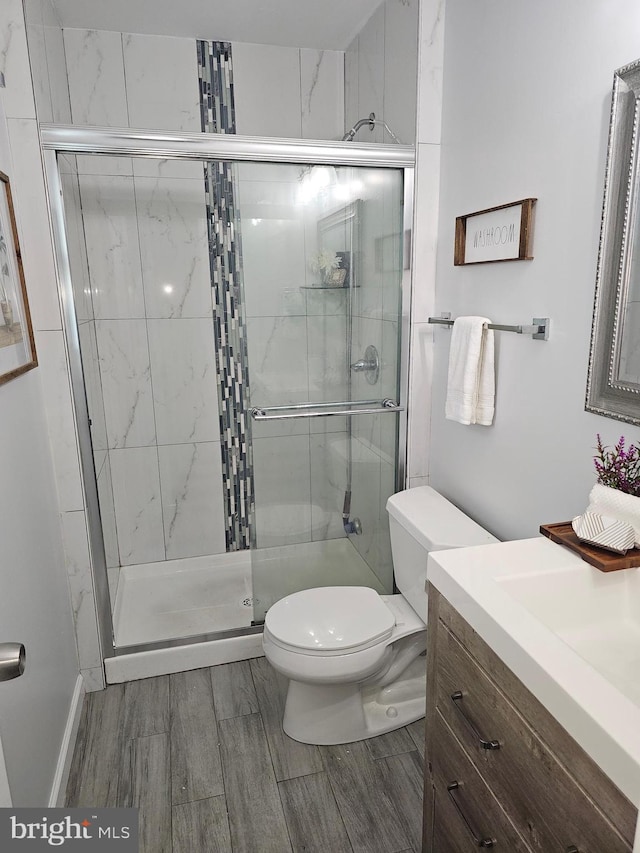 bathroom featuring walk in shower, vanity, and toilet