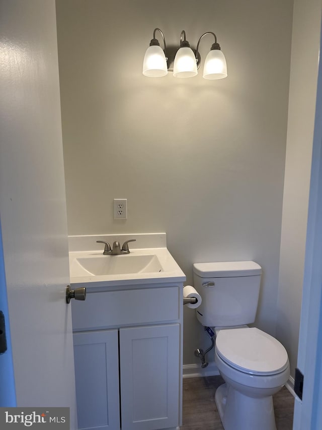 bathroom featuring wood-type flooring, vanity, and toilet