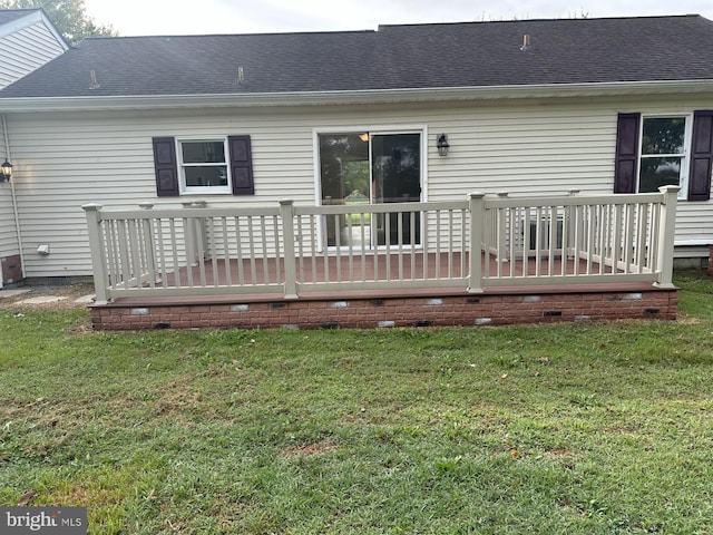 rear view of property with a wooden deck and a lawn