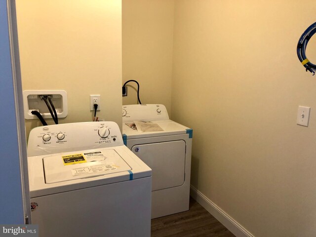 washroom with washer and clothes dryer and dark wood-type flooring