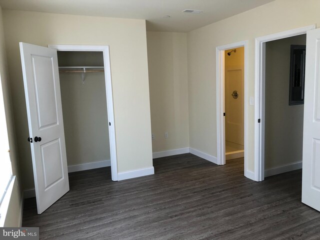 unfurnished bedroom featuring a closet and dark hardwood / wood-style floors