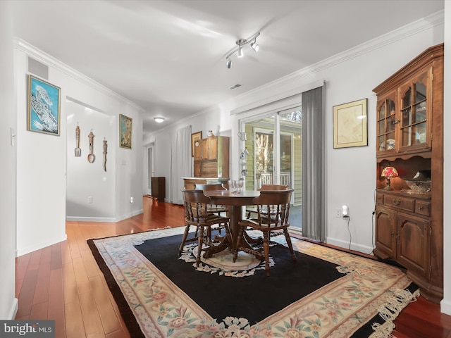 dining area with crown molding and wood-type flooring