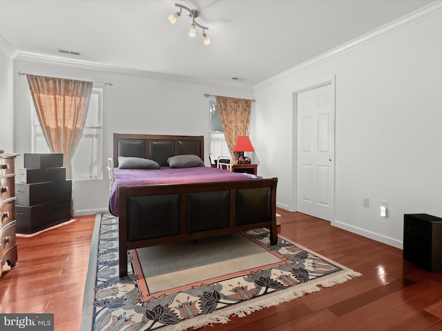 bedroom with ornamental molding and hardwood / wood-style floors