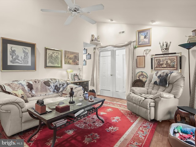 living room featuring dark hardwood / wood-style floors, ceiling fan, and vaulted ceiling