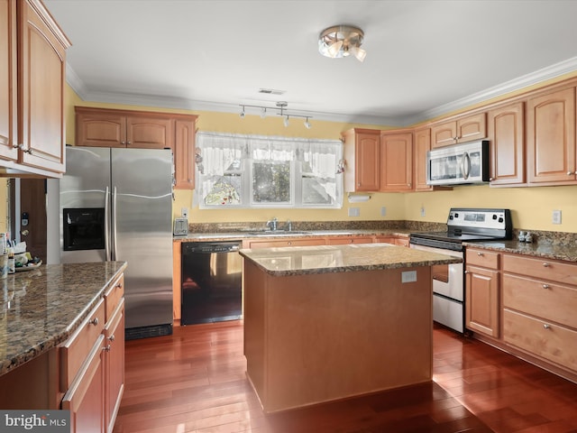 kitchen with dark hardwood / wood-style flooring, appliances with stainless steel finishes, ornamental molding, sink, and a center island