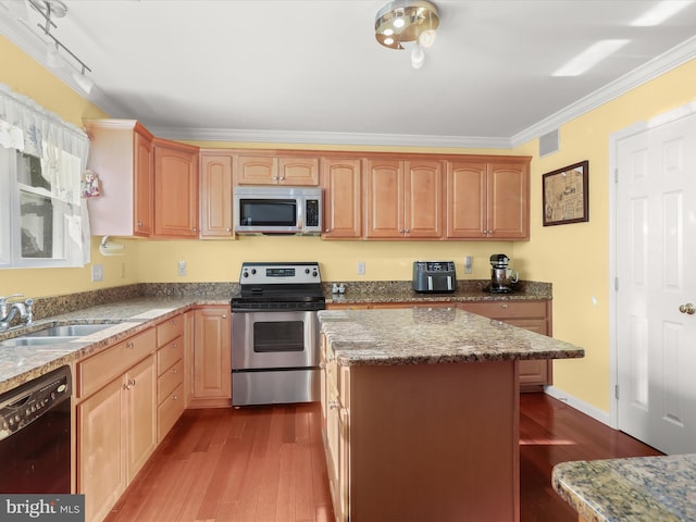 kitchen featuring sink, a center island, stainless steel appliances, crown molding, and hardwood / wood-style flooring