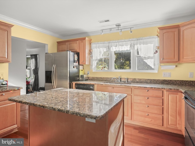 kitchen featuring stone countertops, hardwood / wood-style flooring, stainless steel appliances, ornamental molding, and sink