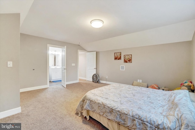 bedroom featuring carpet floors, connected bathroom, and vaulted ceiling